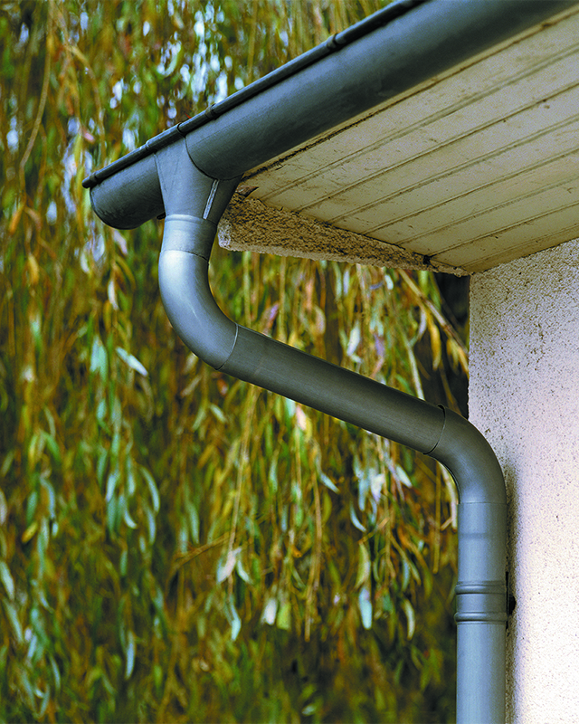 Descente de gouttière en zinc anthracite le long d'une façade
